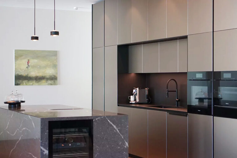 Küchenzeile mit matten Fenix-Fronten und Kücheninsel aus dunklem Quarzcomposite